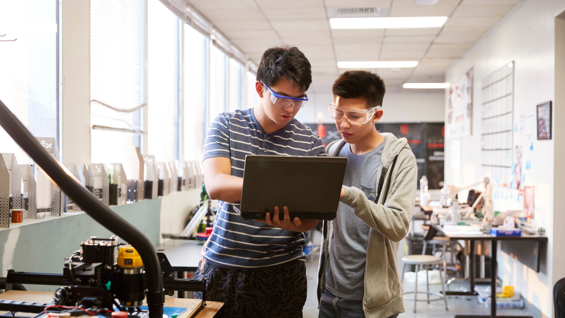 two students in a lab look at a laptop together