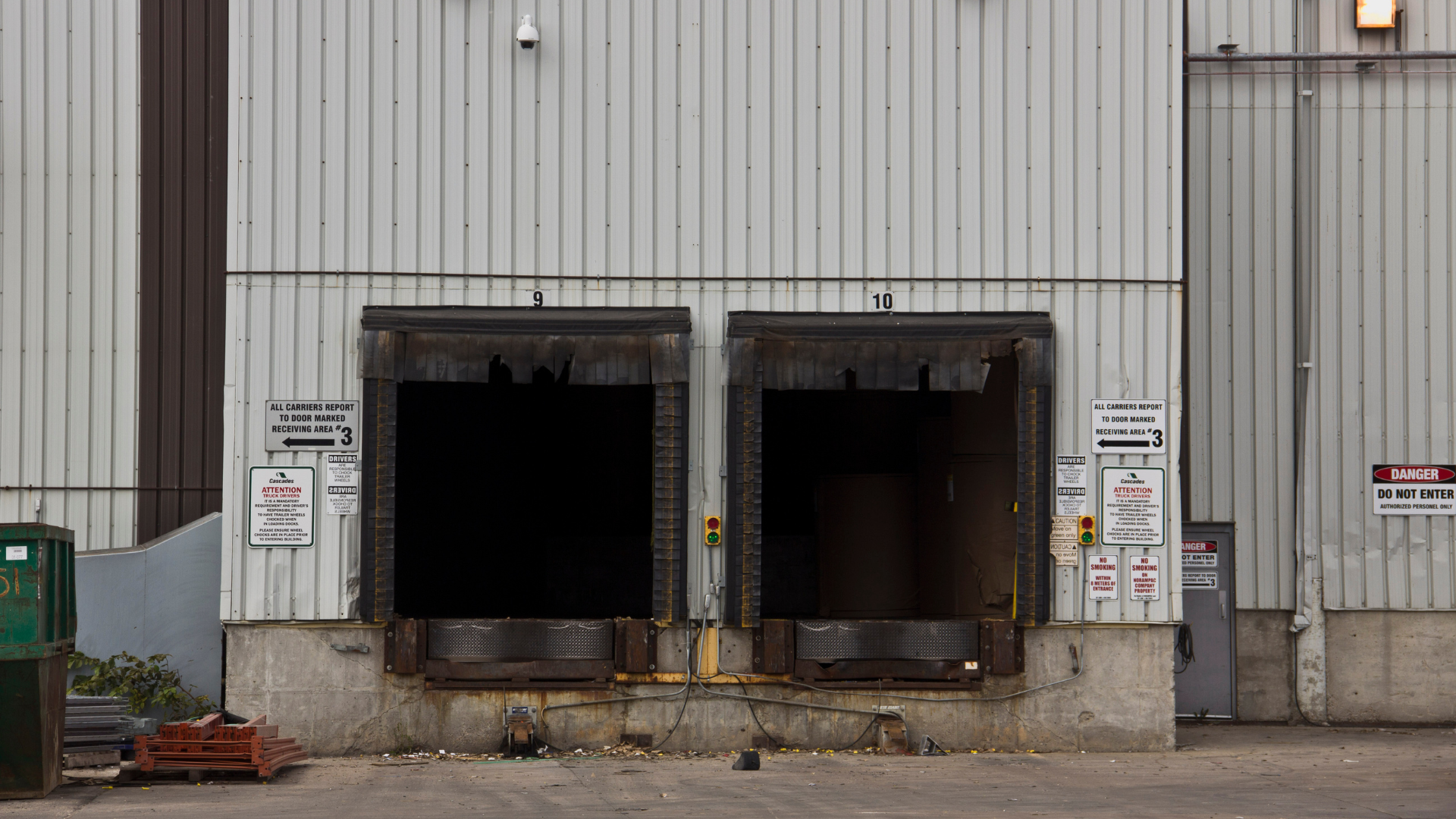 semi loading bays behind an industrial building with a stack of used wooden palettes